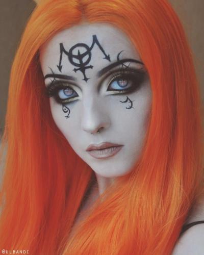 Model in gothic makeup with & an orange wig